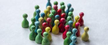 A group of small, colorful wooden figurines or game pieces arranged in a cluster.