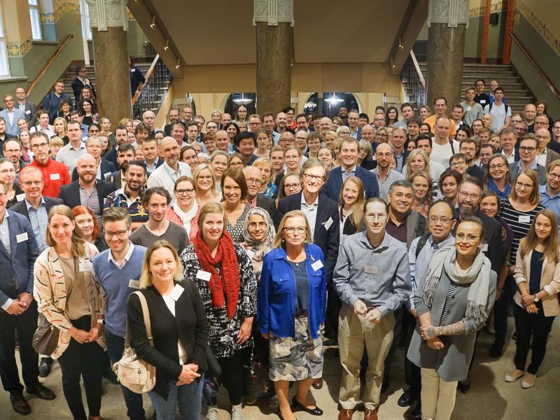 A group photo of FinnGen consortium members with over a hundred people.