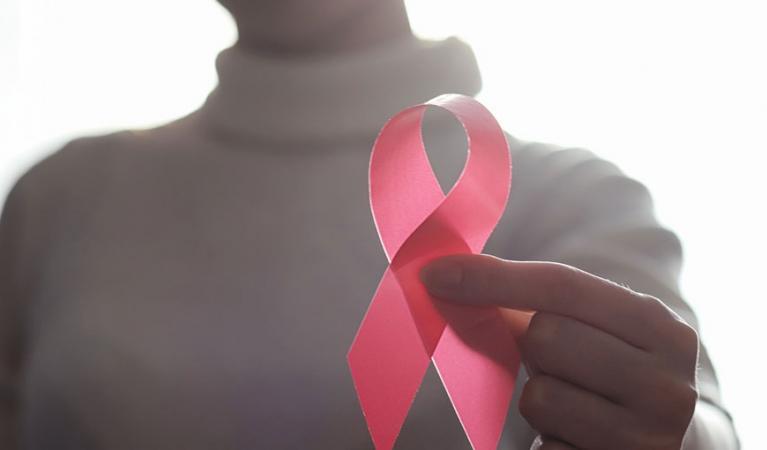 Woman holding a reb ribbon in her hand.