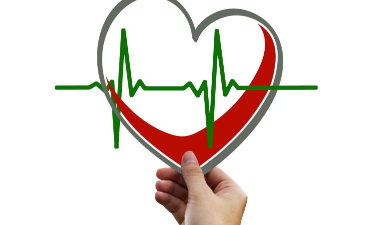 Hand holding a heart-shaped graphic with an ECG line.