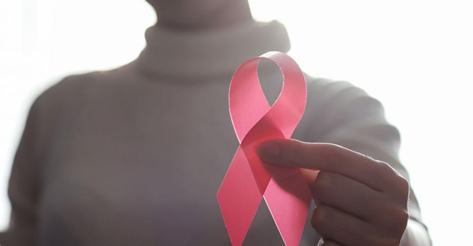 Woman holding a reb ribbon in her hand.