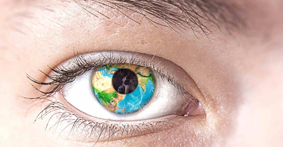 Kohti katsova silmä, jonka pupillissa näkyy maapallo.