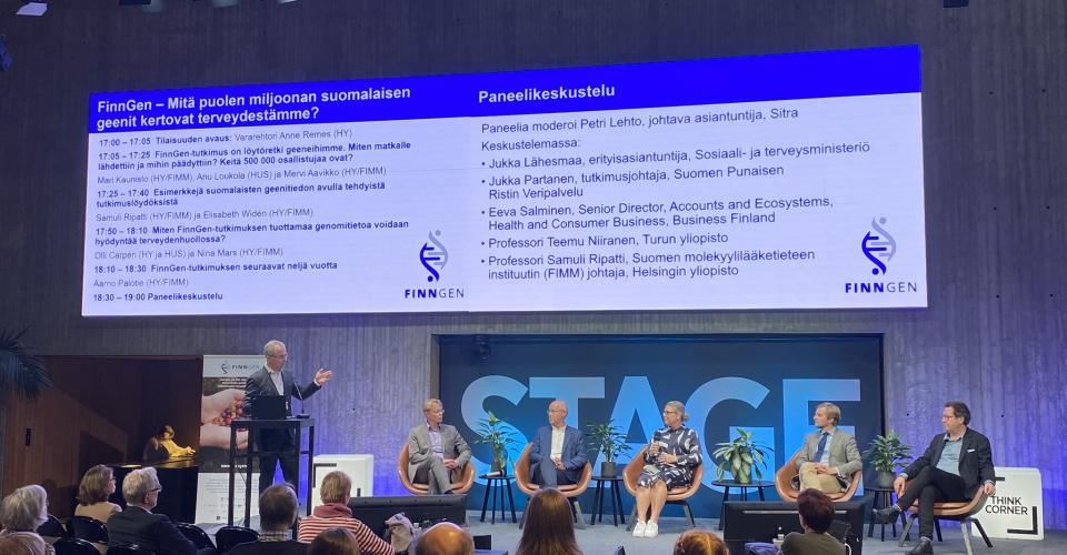 Panelikeskustelu alkamassa, lavalla paneelin vetäjä ja viisi panelistia, taustalla Tiedekulman STAGE teksti ja ohjelmakalvo.