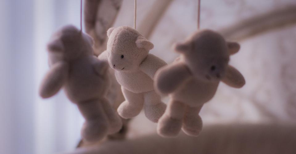 Mobile toy for babies with three soft toys hanging from it.