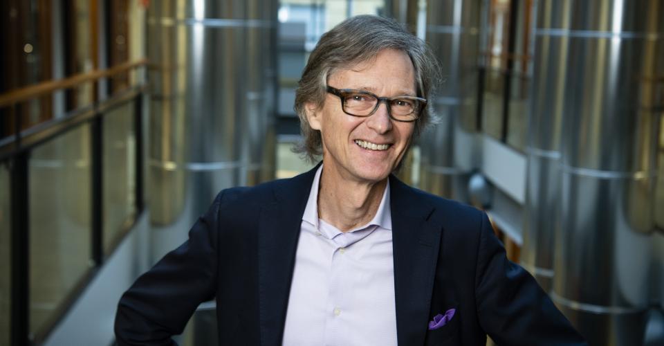 Hymyilevä Aarno Palotie seisomassa portaikossa.